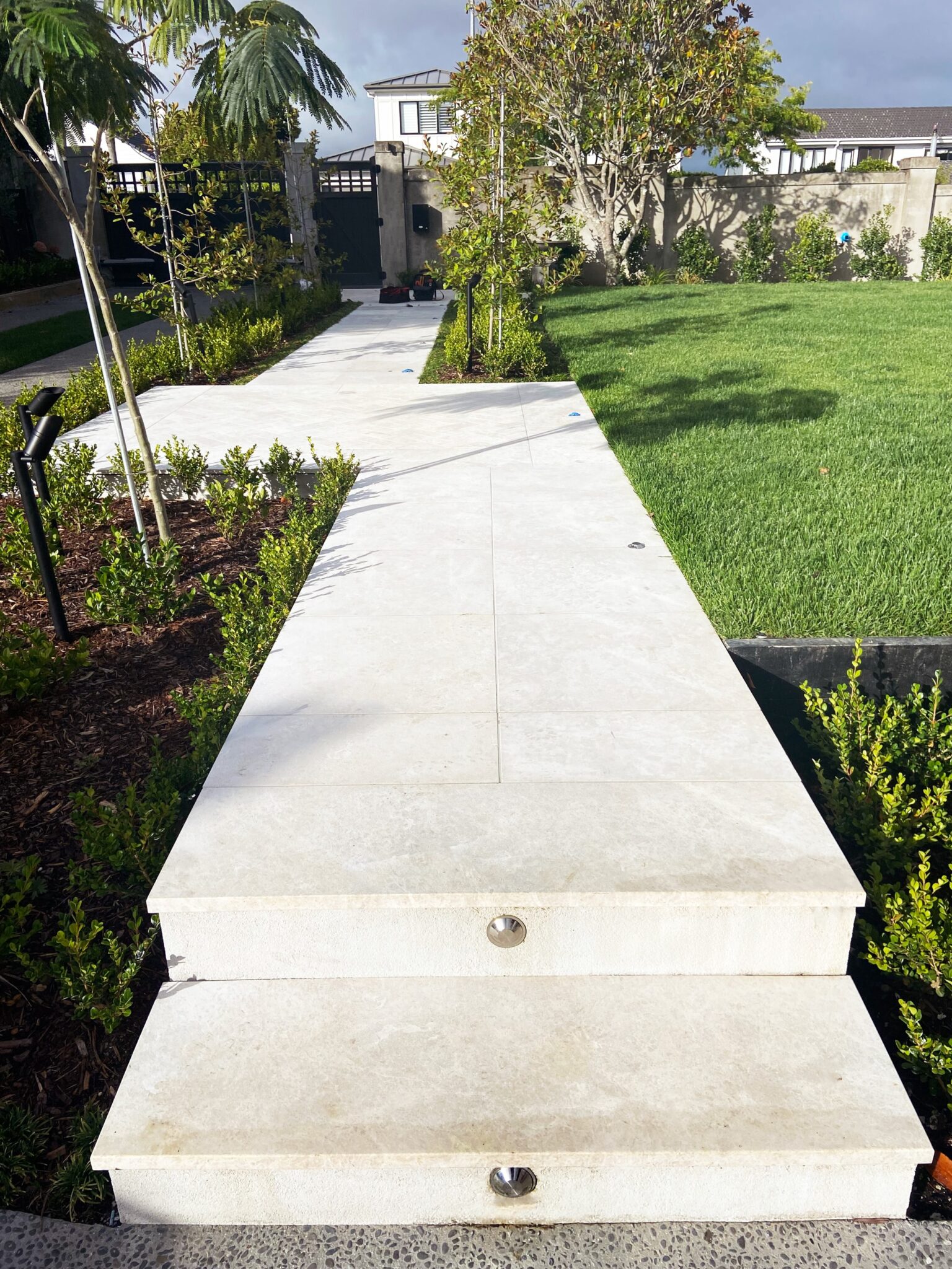 Modux Four Steplights recessed into concrete steps beside a lawn